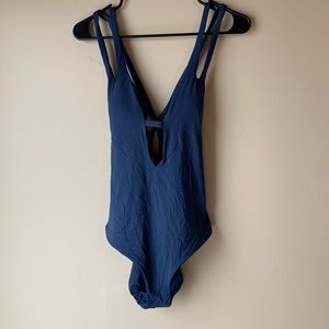 Becca swim one piece with plunging neckline.